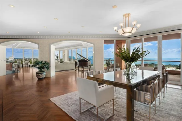 a dining room with furniture a chandelier and wooden floor