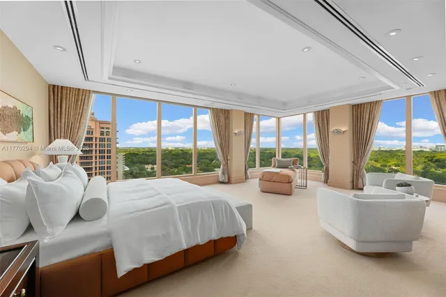 a bedroom with a bed and large windows