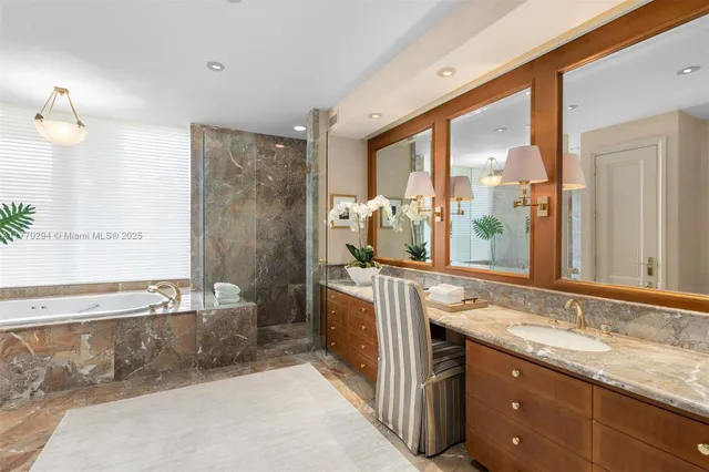 a bathroom with a granite countertop tub sink and mirror