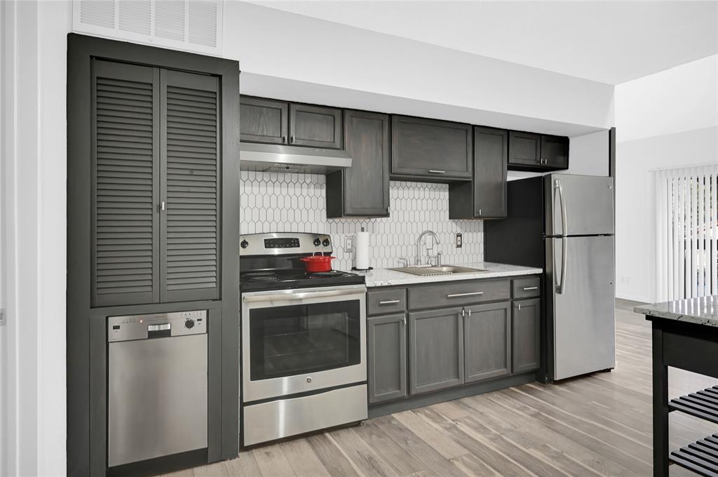 a kitchen with stainless steel appliances a stove microwave and refrigerator