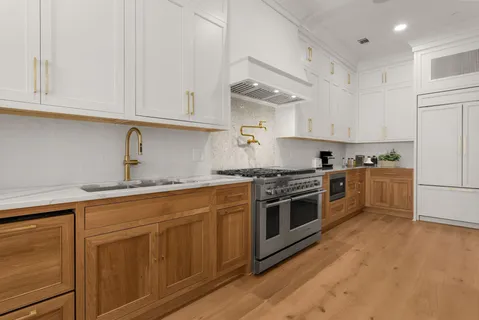 a kitchen with granite countertop white cabinets and white appliances