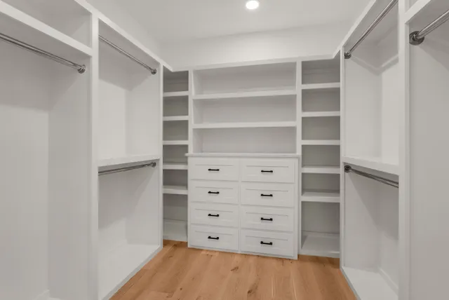 a view of walk in closet with empty racks
