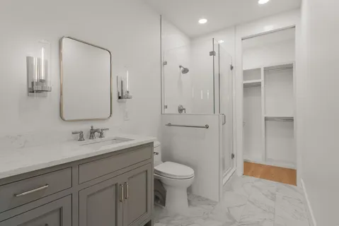 a bathroom with a toilet a sink a mirror and vanity