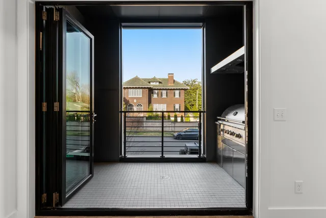 a view of a hallway with wooden floor and windows