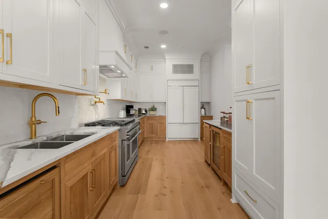 a kitchen with granite countertop a sink stove and refrigerator