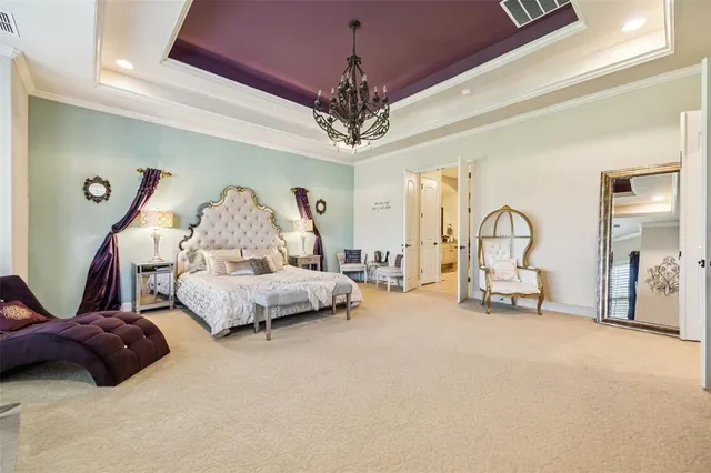 a spacious bedroom with furniture and a chandelier