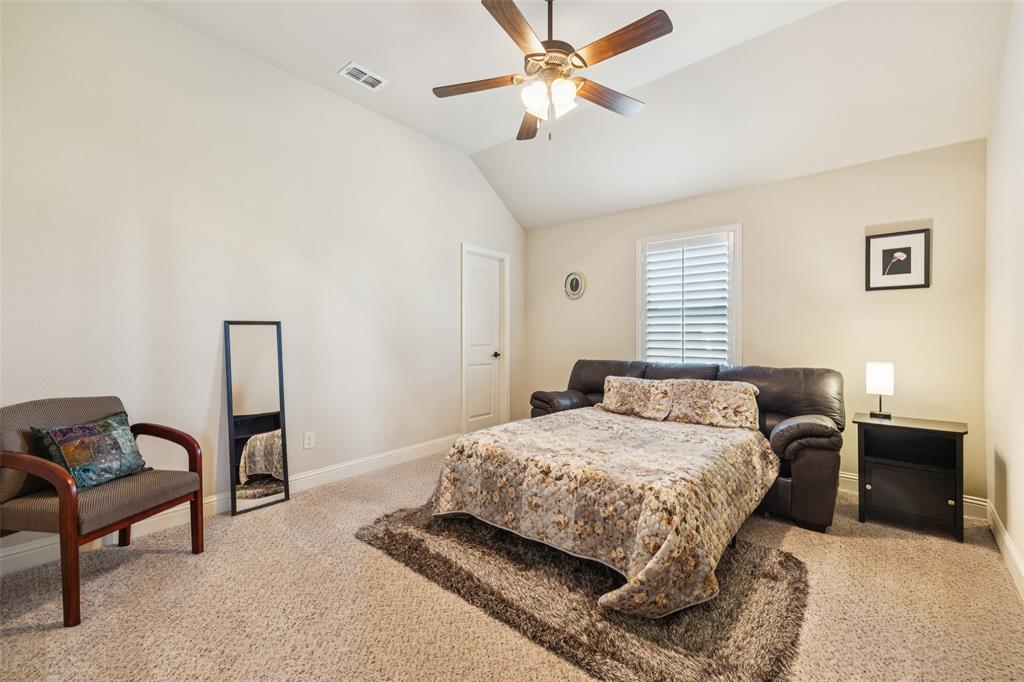 715 Simmons Road Double Oak, TX 75077 - Photo 29 of 40 a bedroom with a bed and a chandelier