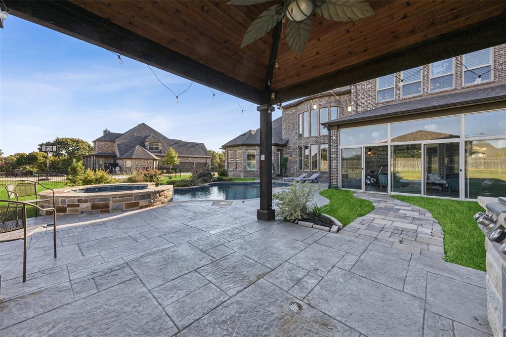 715 Simmons Road Double Oak, TX 75077 - Photo 35 of 40 a view of a porch with a table and chairs under an umbrella