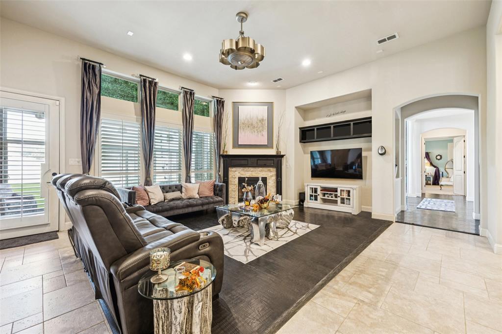 715 Simmons Road Double Oak, TX 75077 - Photo 10 of 40 a living room with furniture a flat screen tv and a fireplace