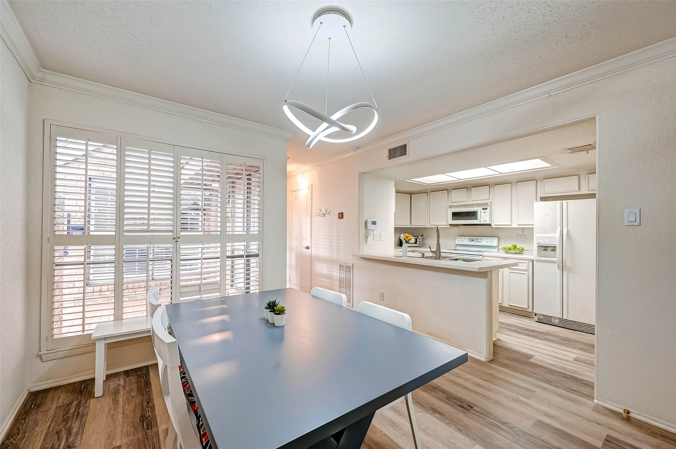 1908 Augusta Drive, Unit 7 Houston, TX 77057 - Photo 15 of 33 a large kitchen with a table chairs and a wooden floor