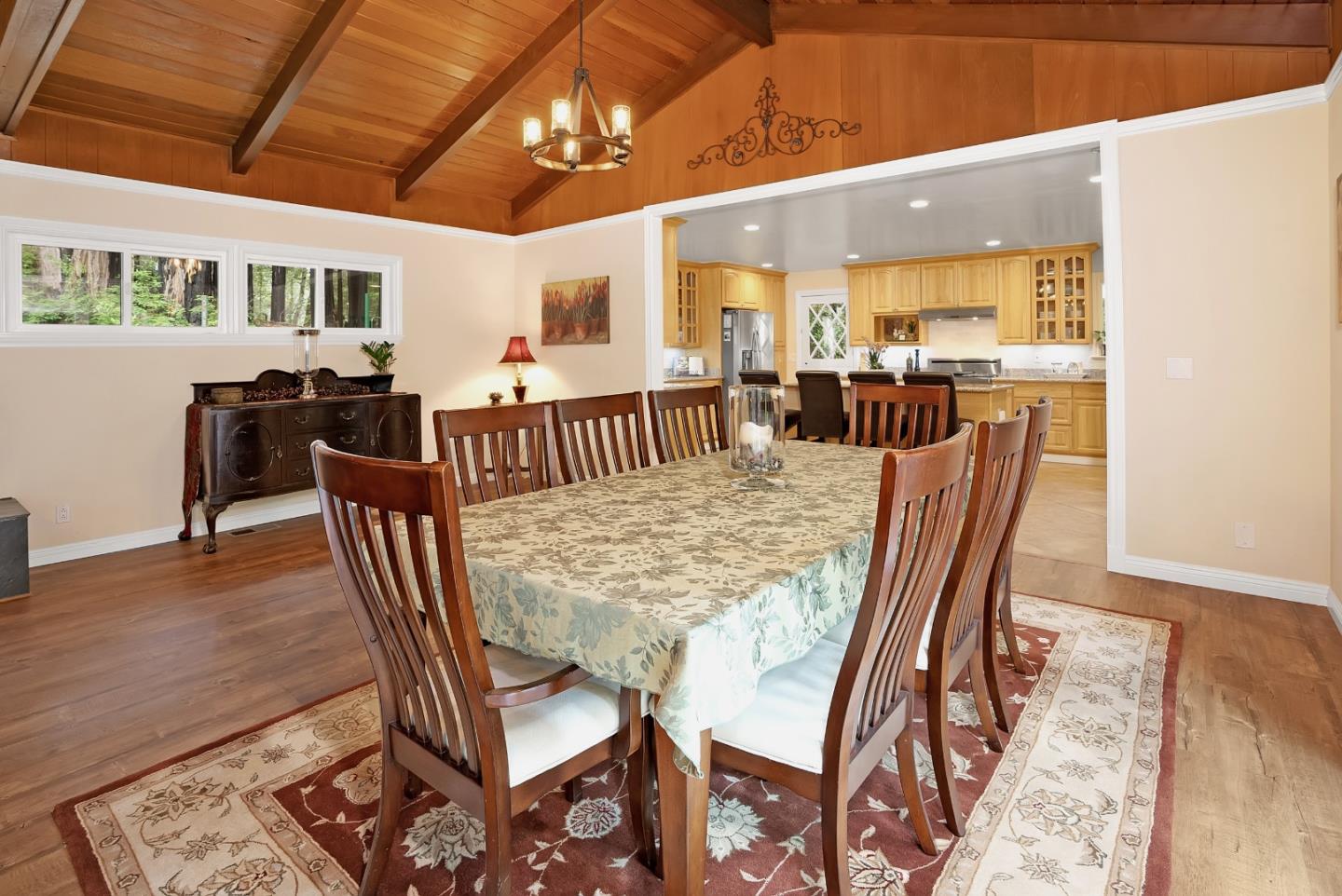 169 Sequoia Grove Ben Lomond, CA 95005 - Photo 28 of 42 a view of a dining room and livingroom with furniture wooden floor a rug a painting and a chandelier