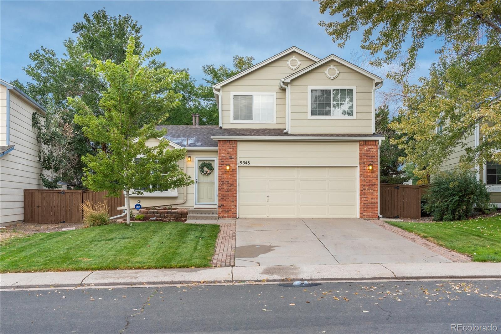 a front view of a house with a garden and garage