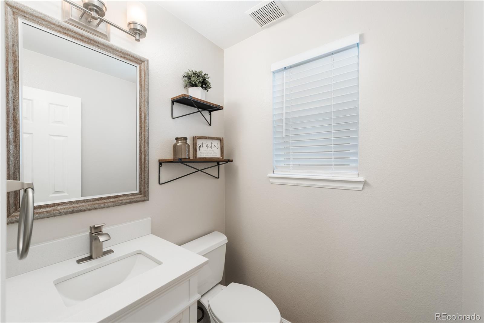9548 South Castle Ridge Circle Highlands Ranch, CO 80129 - Photo 13 of 31 a bathroom with a sink a toilet and mirror