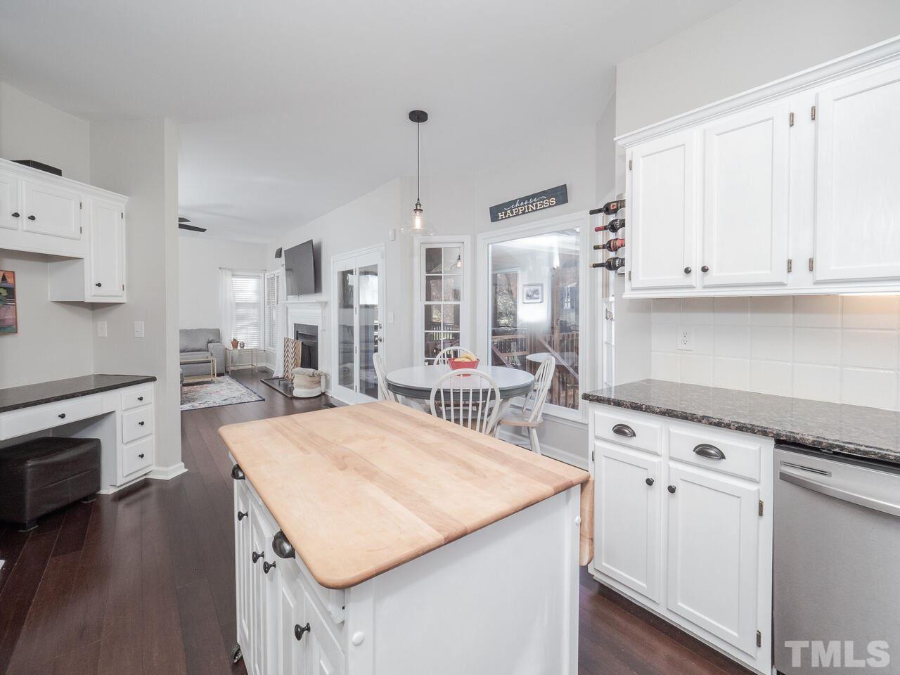 12105 North Exeter Way Raleigh, NC 27613 - Photo 11 of 27 a kitchen with granite countertop white cabinets and white appliances