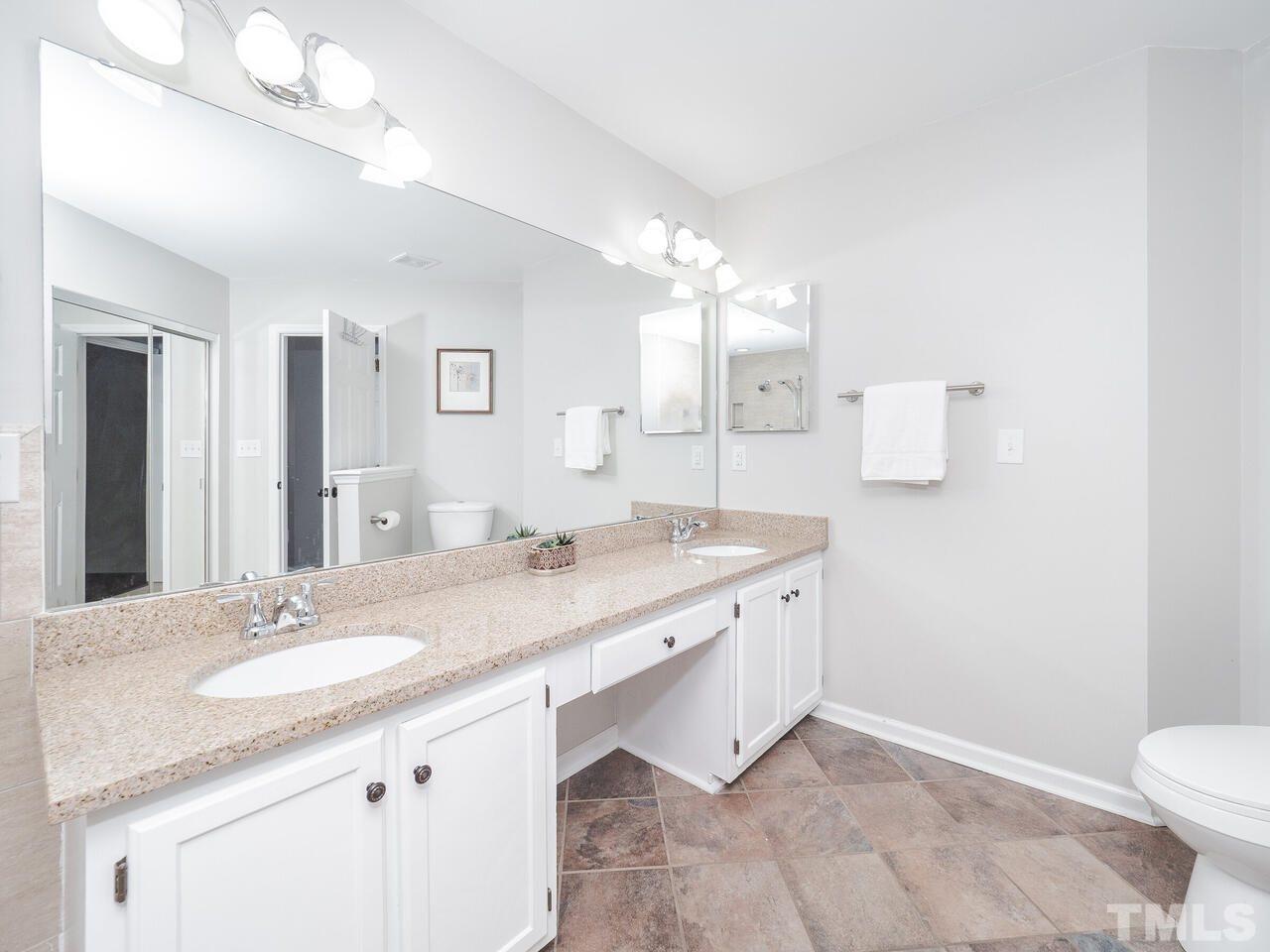 12105 North Exeter Way Raleigh, NC 27613 - Photo 19 of 27 a bathroom with a granite countertop sink a toilet and a mirror