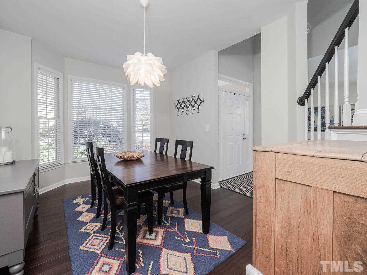 12105 North Exeter Way Raleigh, NC 27613 - Photo 7 of 27 a view of a dining room with furniture window and wooden floor