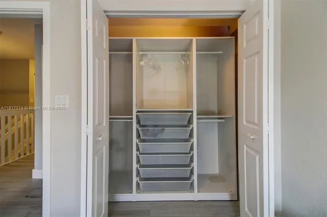 a view of walk in closet with empty room