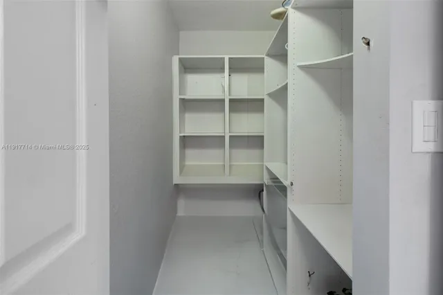 a view of walk in closet with empty racks