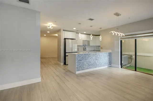 a view of a kitchen with a refrigerator and a sink