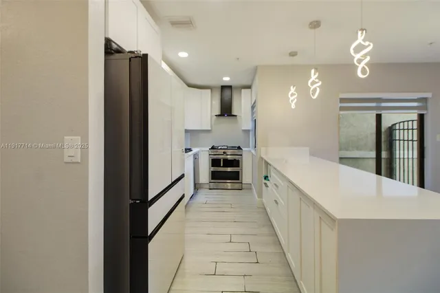 a large kitchen with a large counter top cabinets and stainless steel appliances