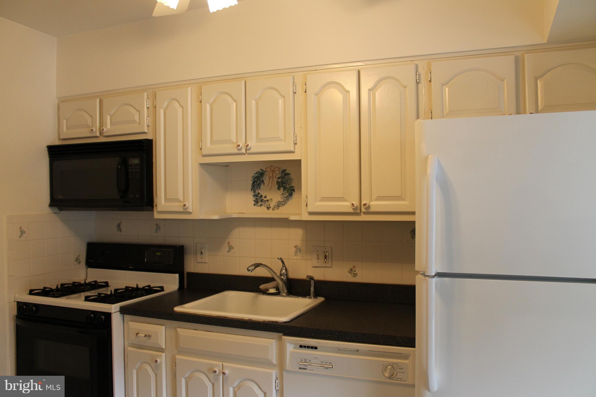 23 Hamill Road, Unit 23F Baltimore, MD 21210 - Photo 4 of 11 a kitchen with a refrigerator and a stove