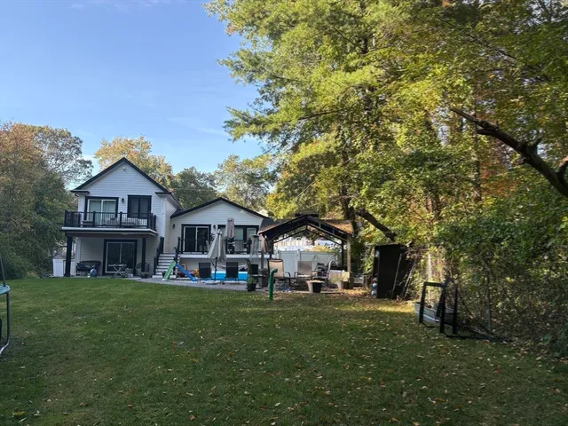 a front view of a house with a garden and trees