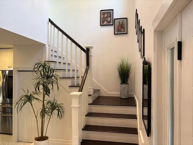 a view of entryway and hall with wooden floor