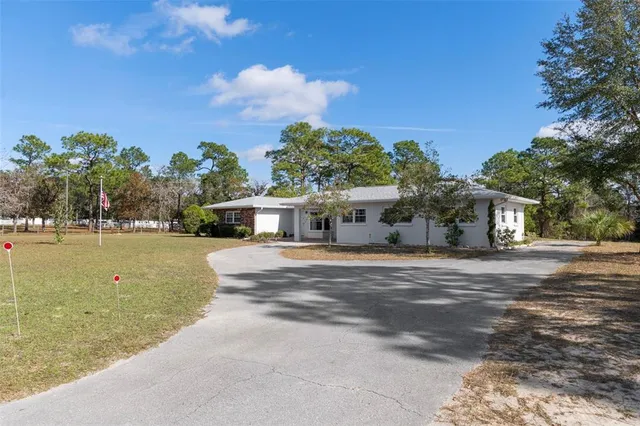 a front view of a house with a garden and trees