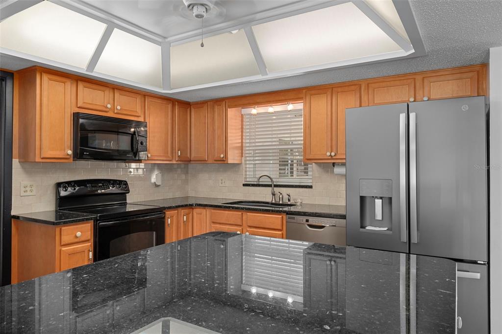 649 Southwest Bend Point Lecanto, FL 34461 - Photo 18 of 50 a kitchen with stainless steel appliances granite countertop a refrigerator a sink a stove top oven and a dishwasher