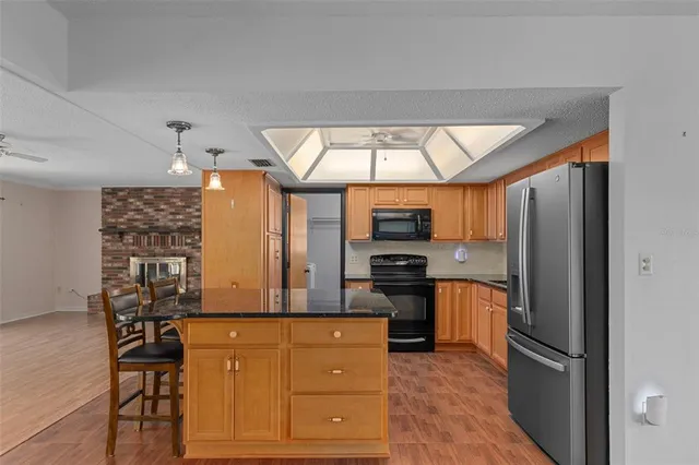 a kitchen with stainless steel appliances granite countertop a stove refrigerator and microwave