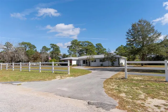 a view of a house with swimming pool and a yard