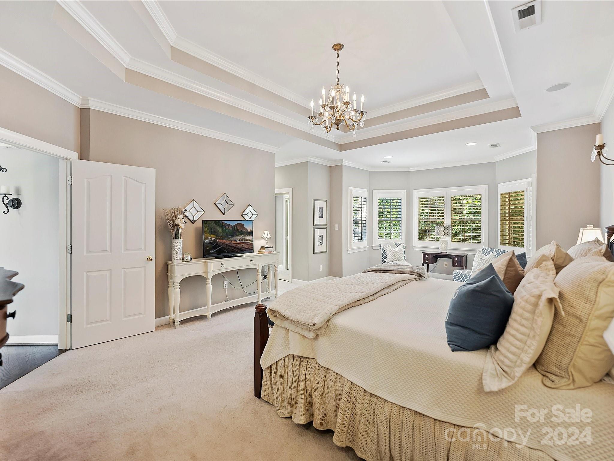 10309 Riesling Court Charlotte, NC 28277 - Photo 28 of 44 a spacious bedroom with a bed a chandelier and dresser