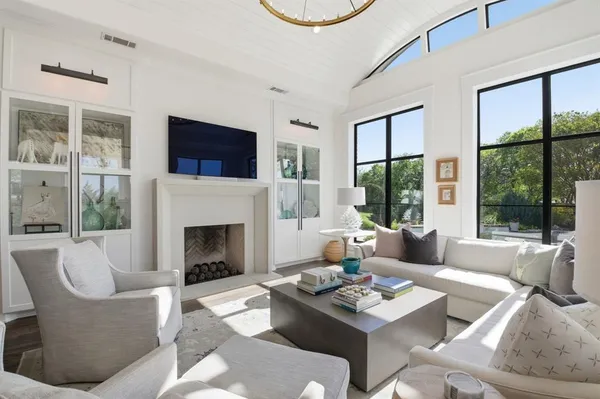 a living room with furniture a fireplace and a large window