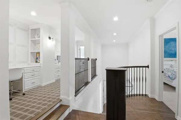 a view of a hallway with wooden floor and staircase