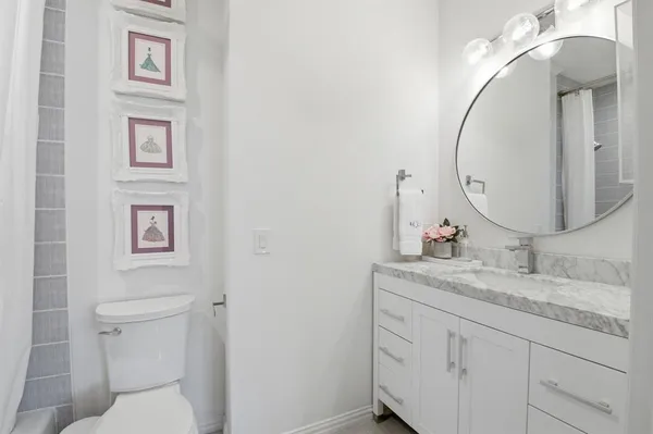 a bathroom with a granite countertop sink mirror and toilet