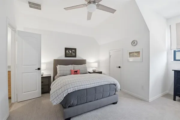 a bedroom with a bed and a ceiling fan