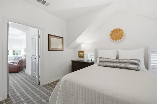 a bedroom with a bed and painting on the wall