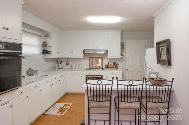 a kitchen with stainless steel appliances granite countertop a white cabinets and stove top oven