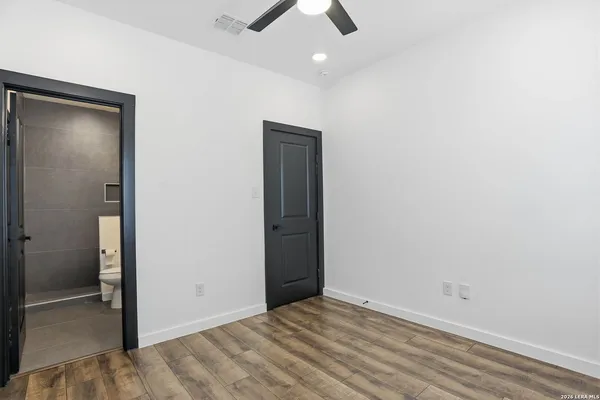 an empty room with closet and a chandelier fan
