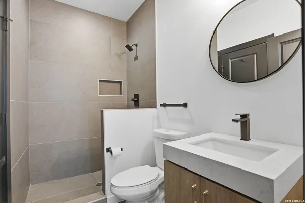 a bathroom with a toilet a sink and mirror
