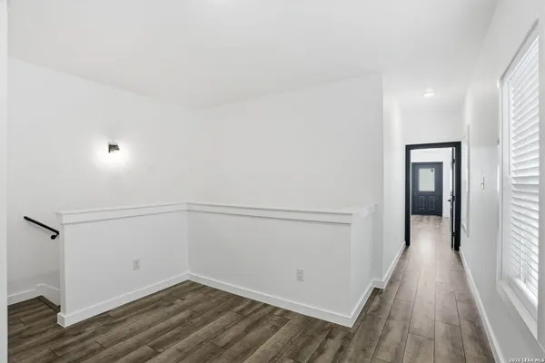 a view of empty room with wooden floor and ceiling fan