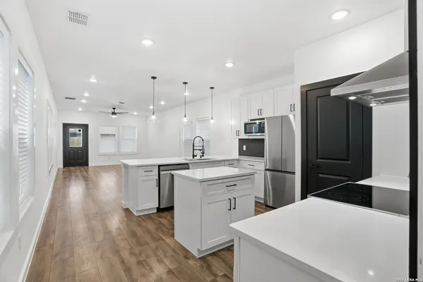 a kitchen with a refrigerator a sink and cabinets