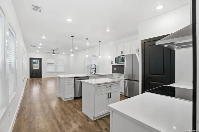 a kitchen with a refrigerator a sink and cabinets