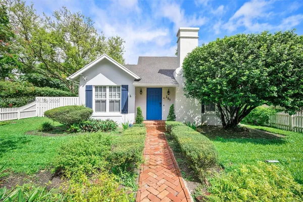 a front view of a house with yard and green space