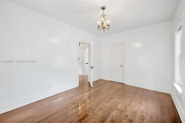 a view of an empty room with wooden floor
