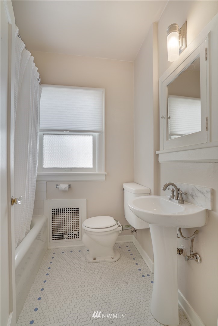 548 North 68th Street Seattle, WA 98103 - Photo 11 of 20 a bathroom with a sink toilet and mirror