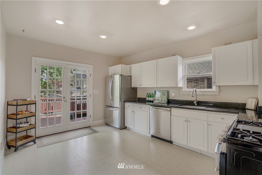 548 North 68th Street Seattle, WA 98103 - Photo 6 of 20 a kitchen with stainless steel appliances a sink stove and cabinets