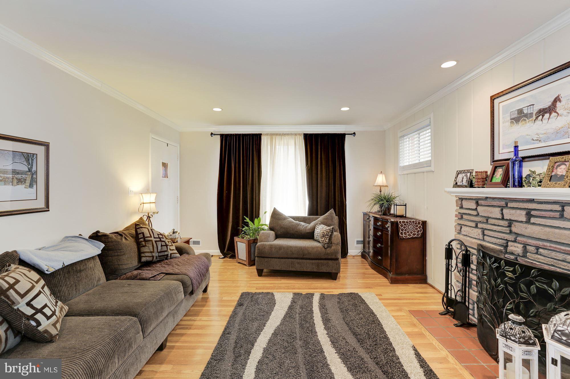 12503 Feldon Street Silver Spring, MD 20906 - Photo 5 of 18 a living room with furniture a fireplace and a flat screen tv
