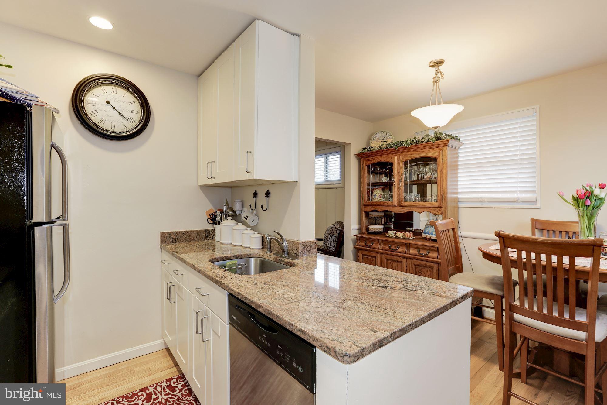 12503 Feldon Street Silver Spring, MD 20906 - Photo 7 of 18 a kitchen with a table chairs and a refrigerator