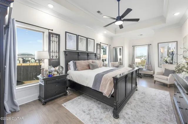 a bedroom with a bed a couch and a large window